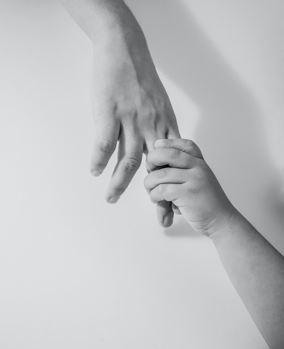 grayscale photo of to hands