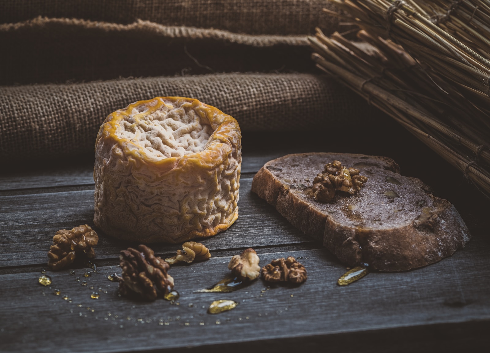 pine cones beside cheese on brown wooden plank